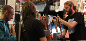 A bartender at Beer Revolution in Oakland, CA pours a couple a pint.