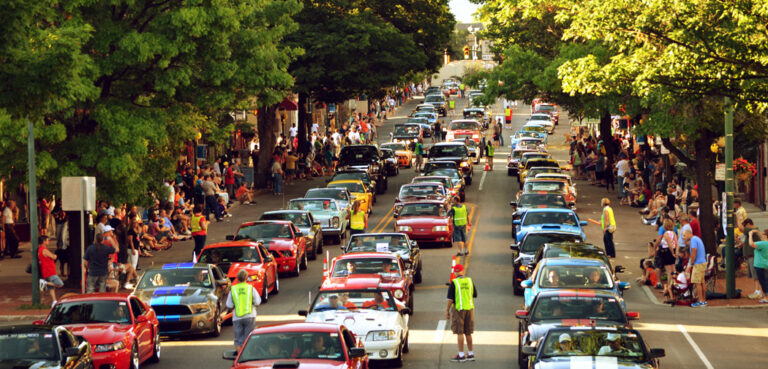Ford Mustangs line up in the street in Carlisle, PA during a car show.