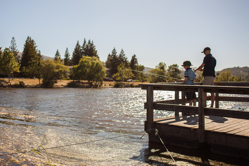 A man and boy fish off a dock in Navoto