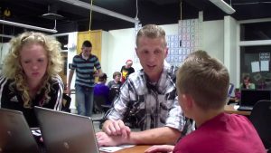 A teacher talks with students at Compass Academy.