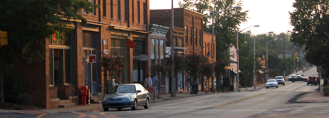 A car drives down a street in historic Carrboro, NC