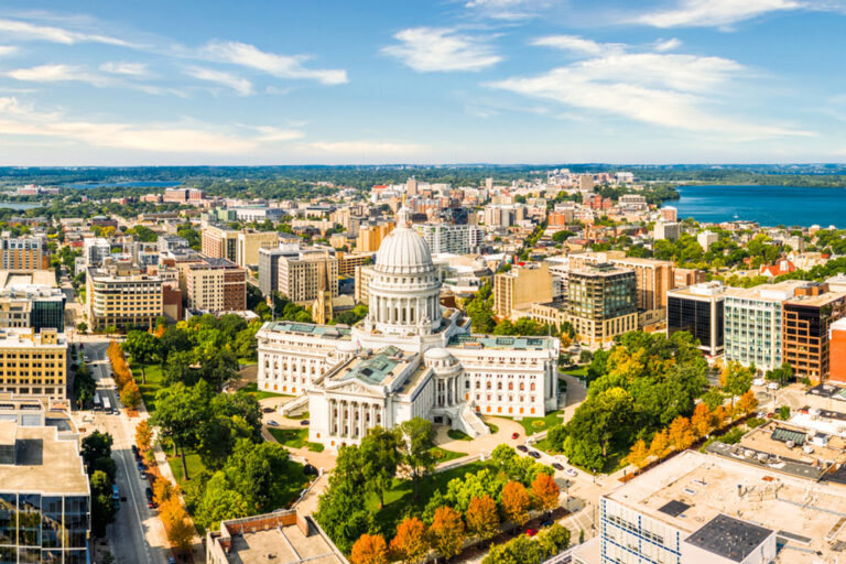 Wisconsin State Capitol and Madison skyline panorama. The Wisconsin State Capitol, houses both chambers of the Wisconsin legislature, Supreme Court and the Office of the Governor.