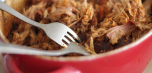 Pulled pork in a red bowl.
