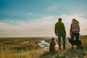 A couple who works remotely stands with their dog along the River’s Edge Trail in Great Falls, Montana.