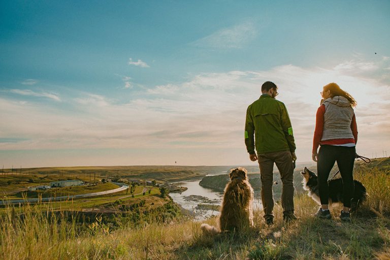 A couple who works remotely stands with their dog along the River’s Edge Trail in Great Falls, Montana.