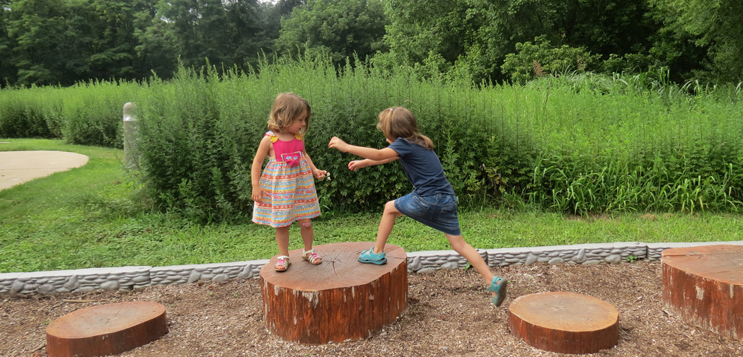 Girls jump across stumps at Croydon Creek Nature Center