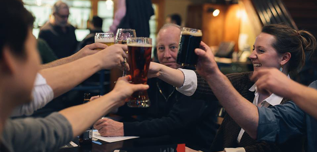 People raise their pint glasses and toast at Wasatch Pubs & Beers.