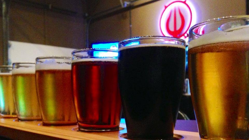 Flight of beers at Straight to Ale with the logo in the back.