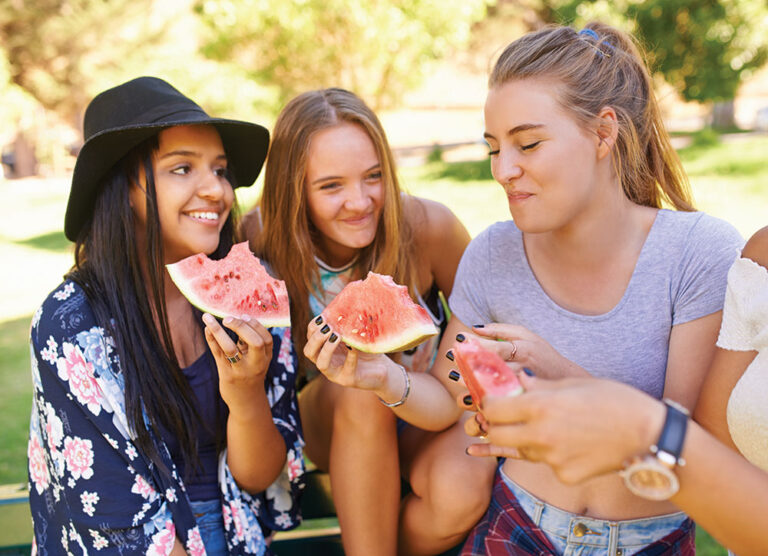 teenage girls eating watermelon