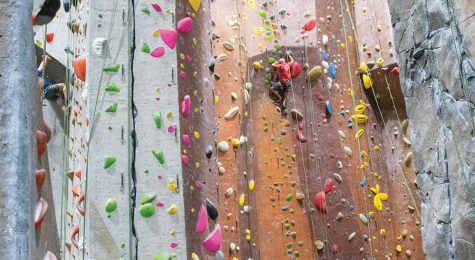 Rock climbers scale wall at indoor facility
