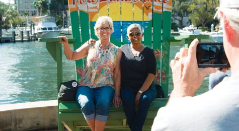 friends sitting on huge chair along riverwalk