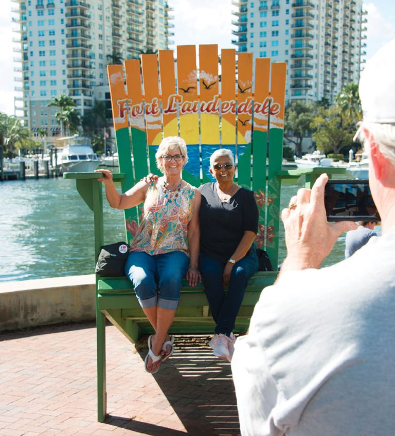 friends sitting on huge chair along riverwalk