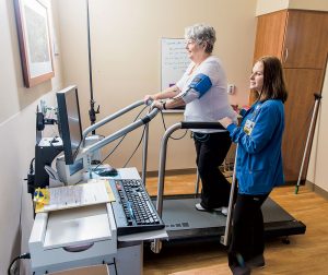 nurse works with patient on treadmill