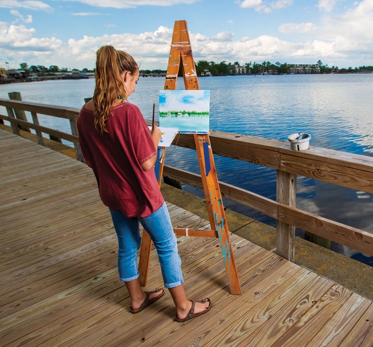 A woman paints along the waterfront in Elizabeth City, NC.