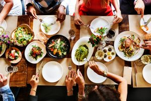 Overhead shot of a farmhouse style table of people eating dinner