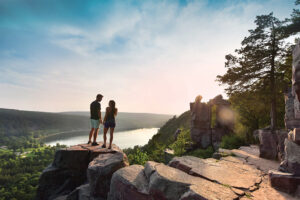 People rock climbing during a hike in the Greater Madison Region.