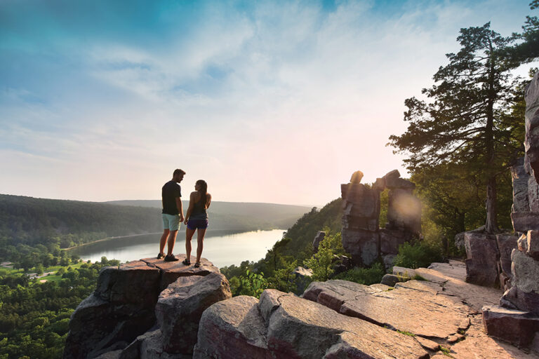 People rock climbing during a hike in the Greater Madison Region.