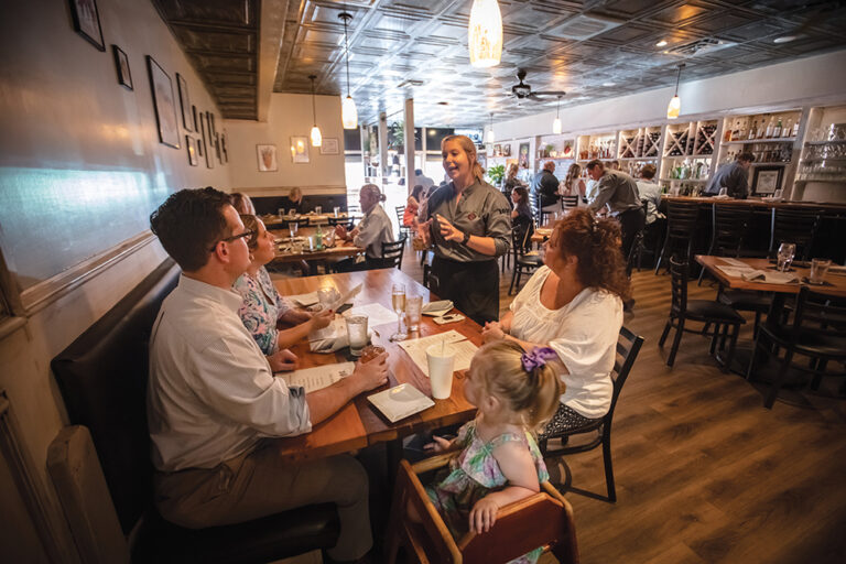 Taylor Perry serves Ray Harrell, left, and his mom Mimi at 1010 Bridge restaurant in Charleston, which is part of the Advantage Valley region of West Virginia.
