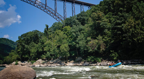 Person kayaking along the New River Gorge Bridge, which is located in the Advantage Valley region of West Virginia.