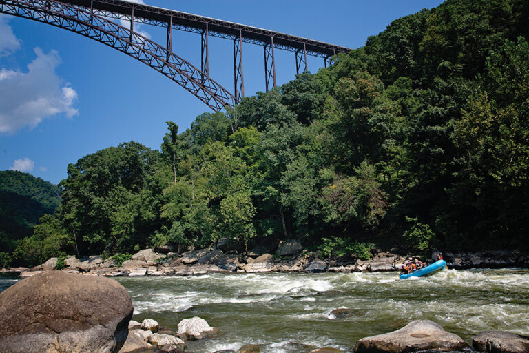 Person kayaking along the New River Gorge Bridge, which is located in the Advantage Valley region of West Virginia.