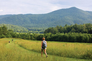 Visitors hike through a field at Cades Cove during Vehicle-Free Day in Great Smoky Mountains National Park in Townsend, Tennessee, which is near Blount County.