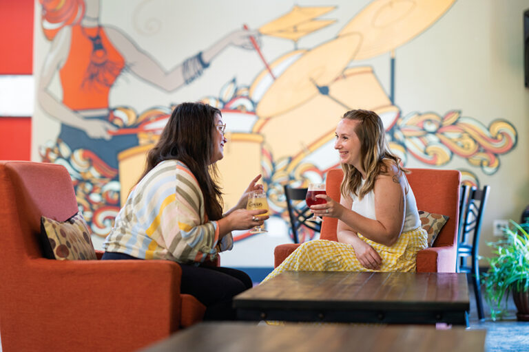 Tammy Combs and Andie Whigham socialize over ginger beers at Ginger's Revenge in Asheville, NC