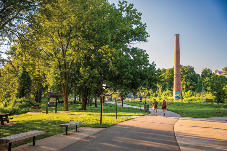 A couple walks along the Wilma Dykeman path in the River Arts District in Asheville, NC