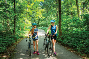 Women walk with their bikes along the Rolling Prairie Trail in the Cedar Valley region of Iowa.