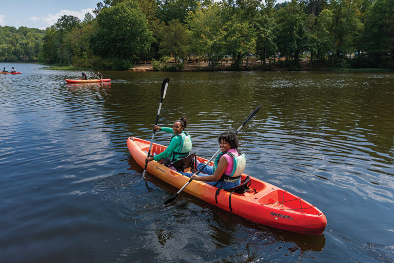 Salem Park, Winston Salem NC, W-S State University Outdoor Rec Class 130L kayaking, Professor Kiboum Kim instructs from the shore, Jade Dark (front) and Alicia Wilkins (Back) navigate the lake.