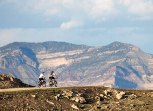 Mountain bikers travel an easy trail into grandiose scenery near Fruita, CO.