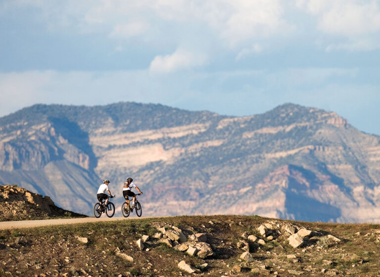Mountain bikers travel an easy trail into grandiose scenery near Fruita, CO.
