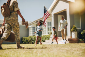 Military mom receiving a warm welcome from her husband and kids. American servicewoman reuniting with her family after serving in the army. Female soldier returning home from deployment.