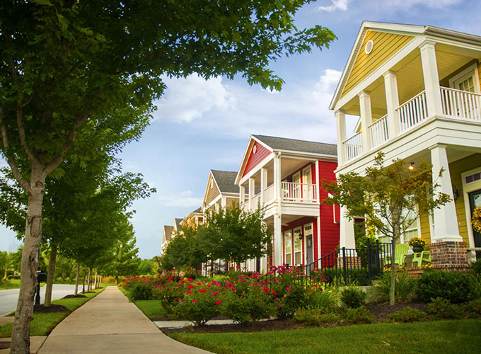Brightly colored homes line the street in a suburban neighborhood in Fayetteville, AR. Tucked in the Ozark Mountains, Fayetteville is surrounded by natural beauty, and residents have access to 70 parks with 40 miles of trails and three lakes.