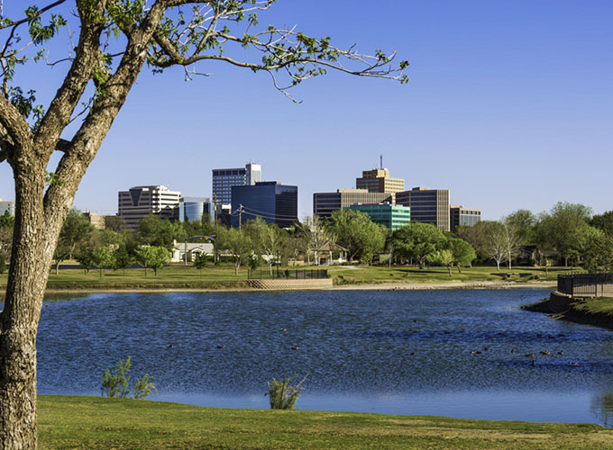 A view of the downtown Midland, TX, skyline across a lake. A diversified economy, affordability and home prices nearly half the national average make Midland one of the best places to live in the U.S.