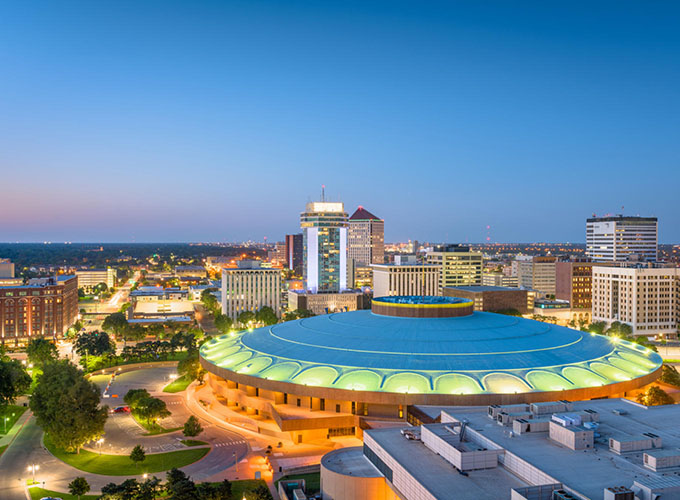 An aerial view of the Wichita, KS, downtown skyline at dusk. Wichita's Western past is balanced by a vibrant downtown with a rich live music scene and an affordable cost of living, making it one of the best places to live in the U.S.