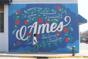 Walking past a mural by artist Lauren Gifford in downtown Ames, Iowa.
