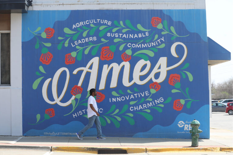 Walking past a mural by artist Lauren Gifford in downtown Ames, Iowa.