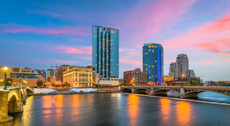 Grand Rapids, Michigan, USA downtown skyline on the Grand River at dusk.
