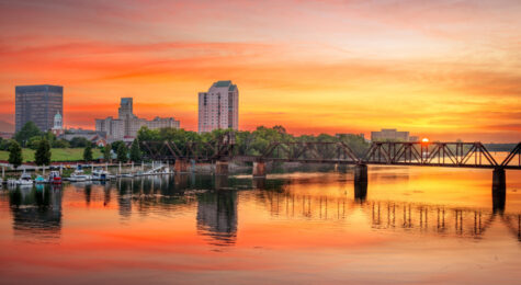 Augusta, Georgia, USA downtown skyline on the Savannah River at sunset.