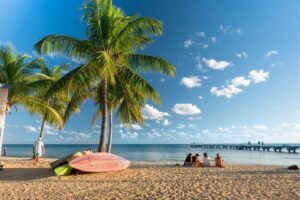 People gather on the sand of Smathers Beach to watch the sunset in tropical Florida USA.