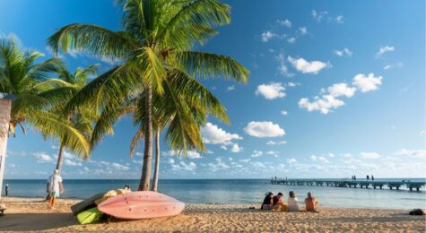 People gather on the sand of Smathers Beach to watch the sunset in tropical Florida USA.